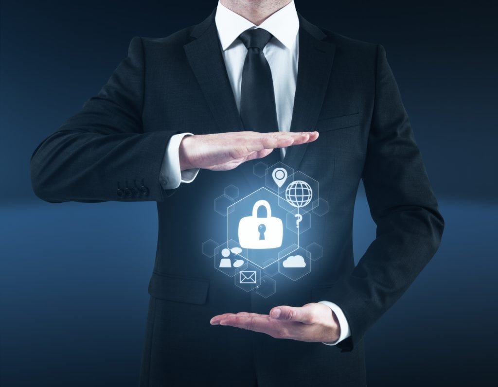 Businessman holding abstract cybersecurity hologram in dark blue interior. Secure concept