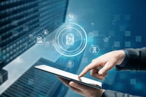 businessman hand pointing at tablet with abstract glowing id fingerprint web protection and security interface on blurry blue bokeh city background. Identification, cybersecurity and priva